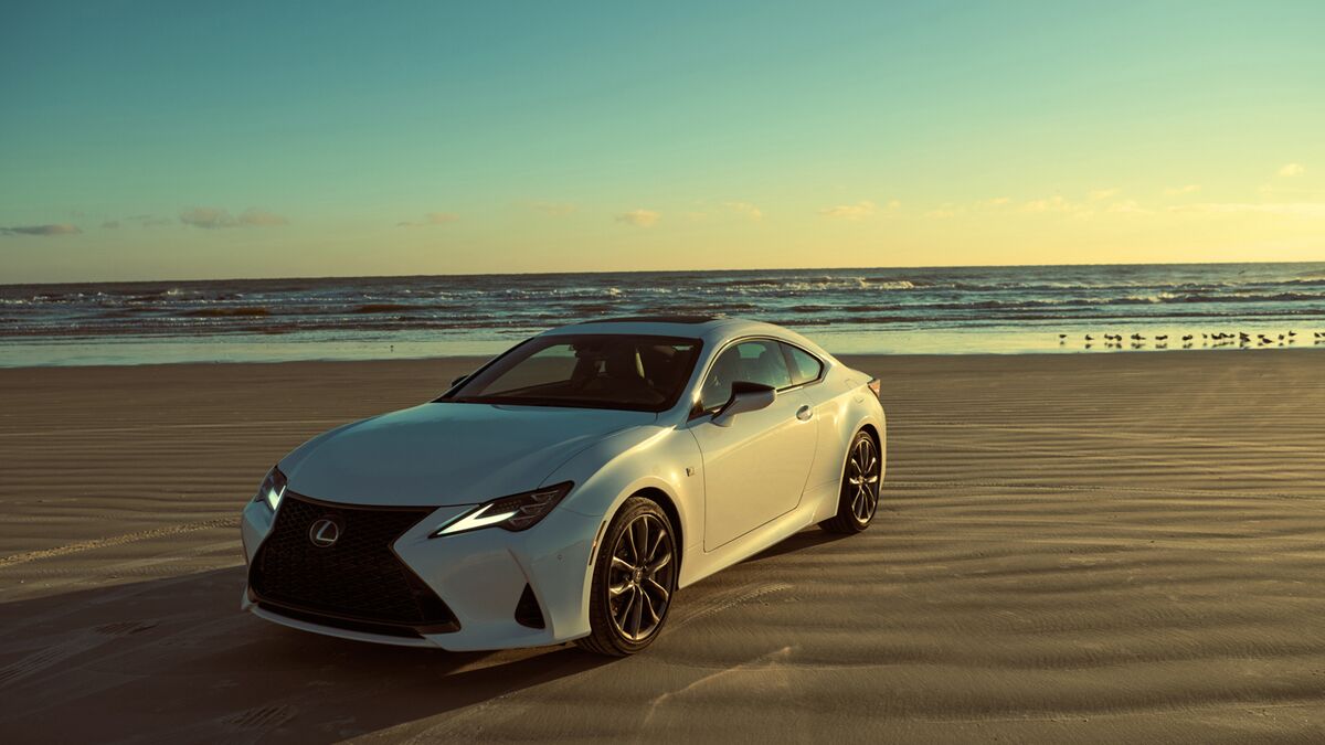 white 2025 Lexus RC on a beach at sunset
