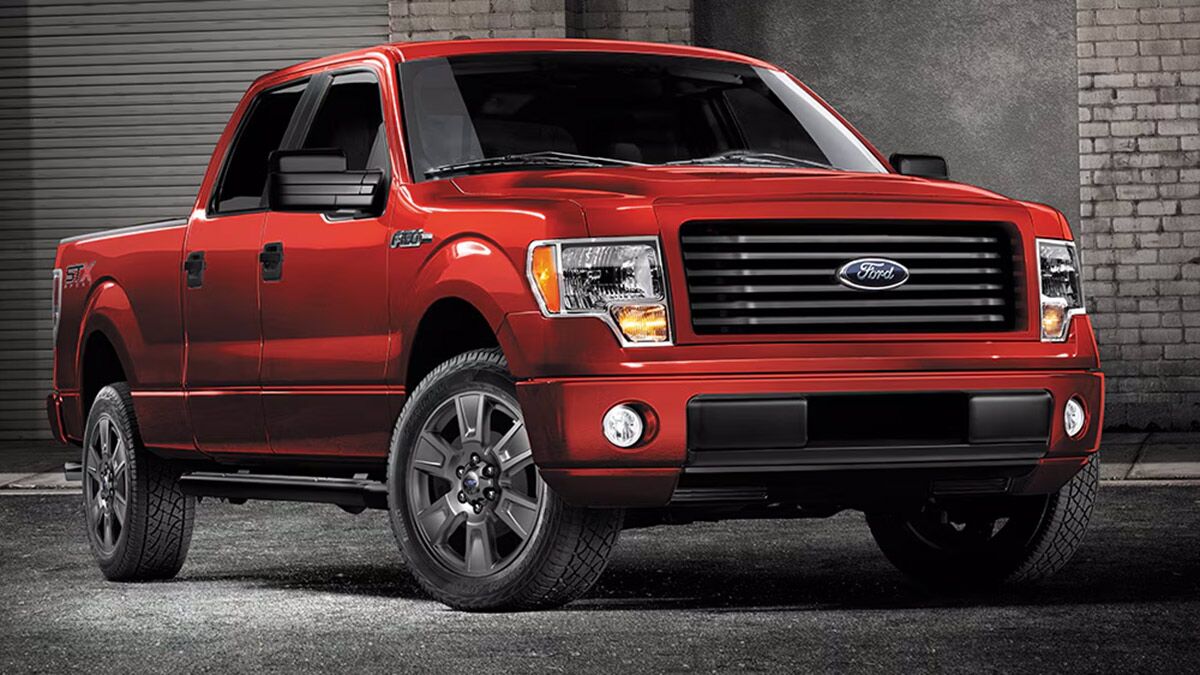 2012 Ford F-250 in red parked buy a brick wall.