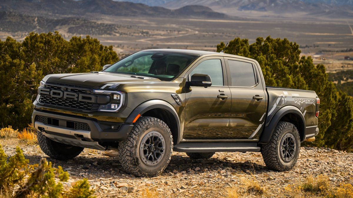 2025 Ford Ranger Raptor off-roading on a trail with mountains in the background.
