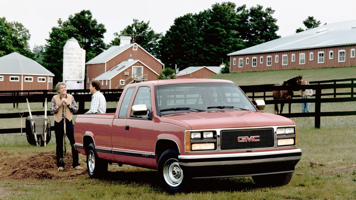 1988 GMC  Sierra on a farm with people standing by the trunk.