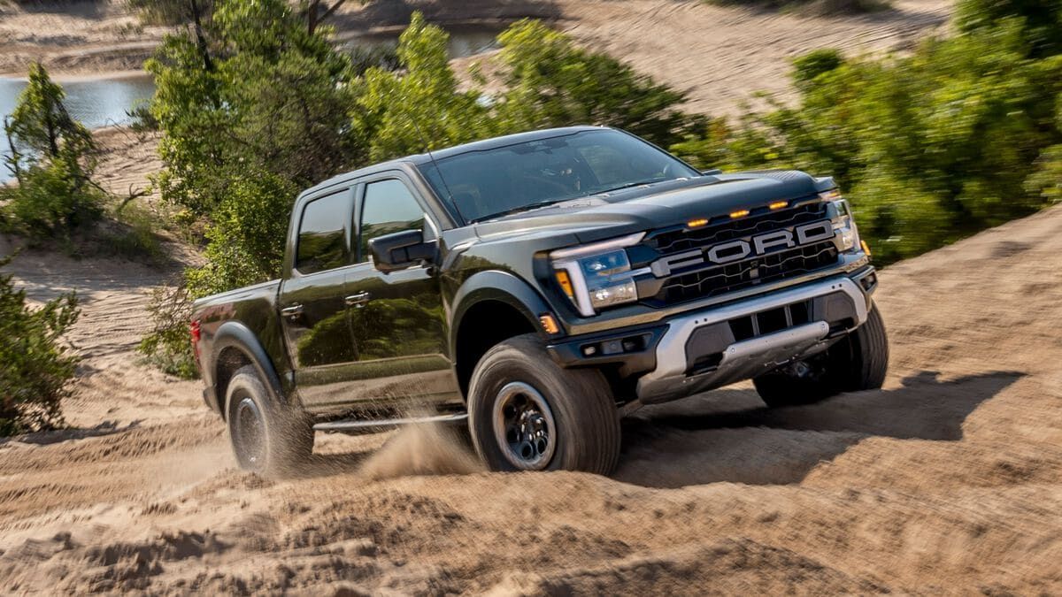 2025 Ford F-150 Raptor driving up a dirt road.