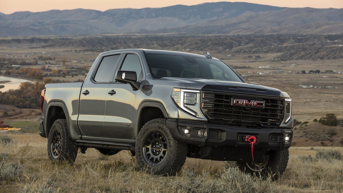 2025 GMC Sierra 1500 AT4X parked on dry grass at sunset.