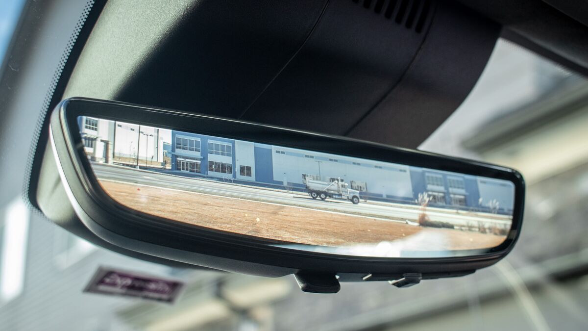 Digital rearview mirror in a 2026 GMC Sierra 1500 showing a live, wide camera view of the road and a truck behind the vehicle.