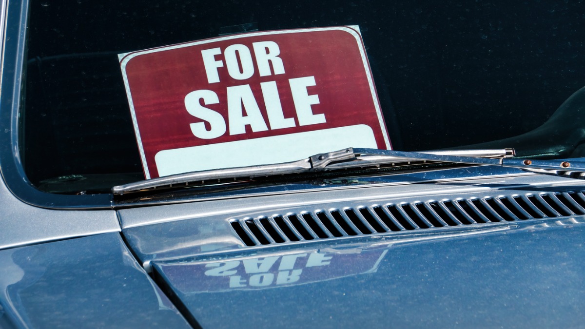 A for sale sign inside an older car
