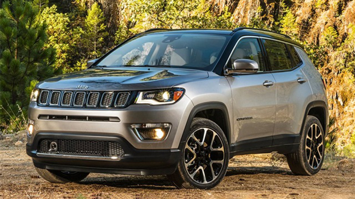2021 Jeep Compass parked in front of bushes.