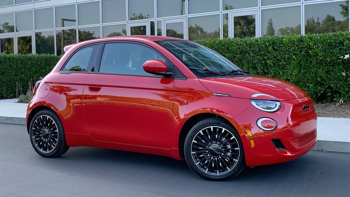 2024 Fiat 500e in red parked next to an office building.