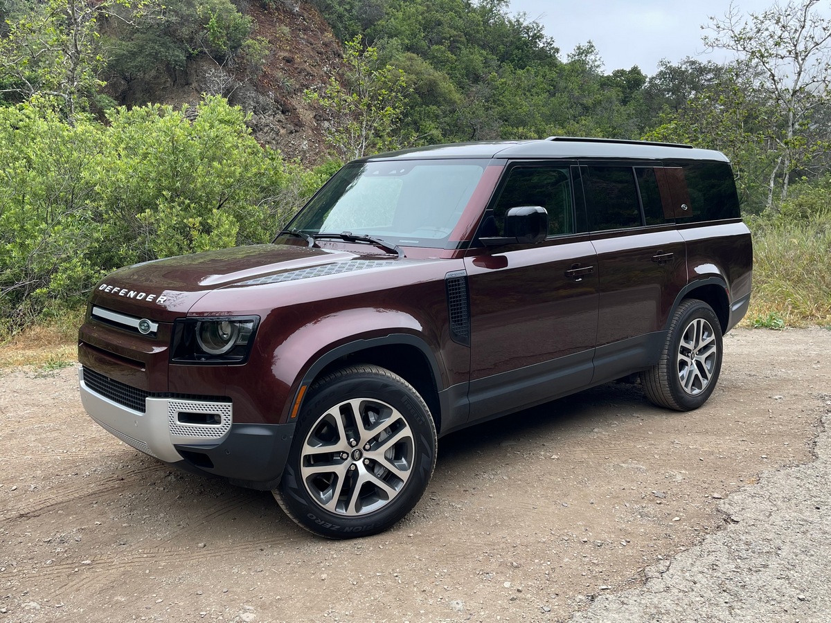 2023 Land Rover Defender 130 in burgundy on a dirt road.